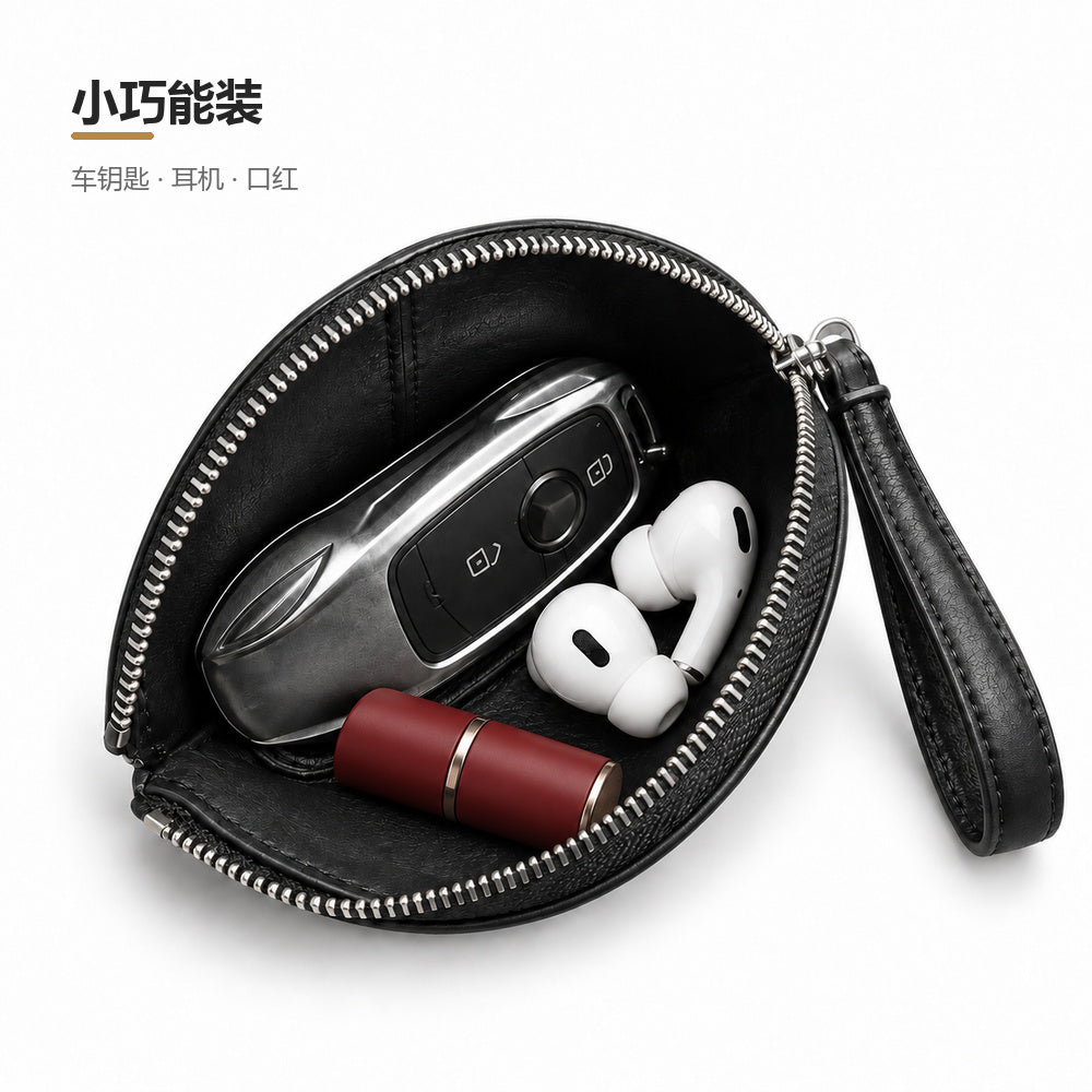 Open black shell-shaped pouch holding a car key fob, earbuds and lipstick, with Chinese product text.