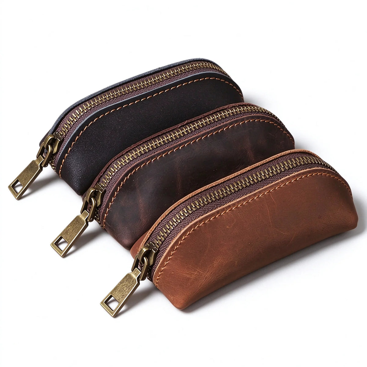 Black, dark brown and brown leather zip key pouches arranged together to show the sample colors.