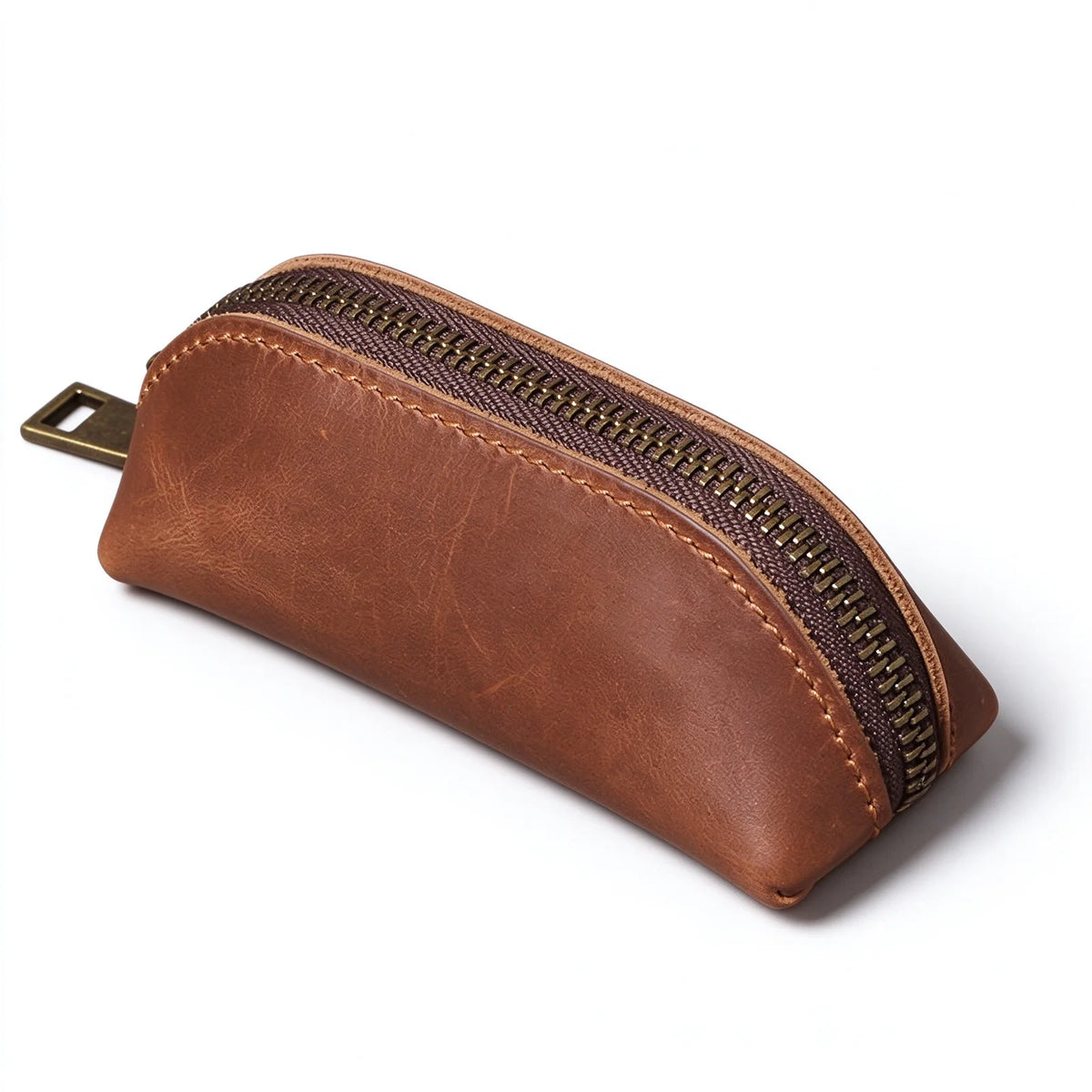 Side view of a brown leather key pouch showing the curved zip opening and stitched edge.