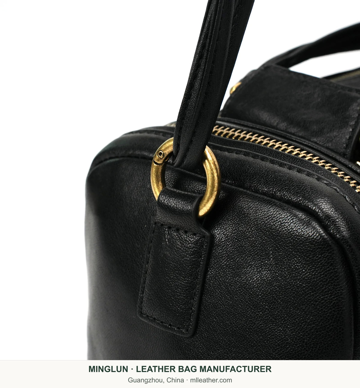 Gold-tone strap ring and zipper detail on black leather Boston bag. MINGLUN manufacturer watermark at the bottom.