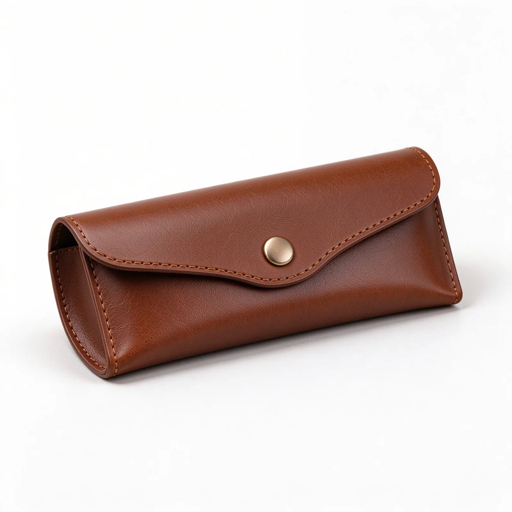 Brown leather eyeglasses case at an angle, showing the stitched flap and gold-tone center button.