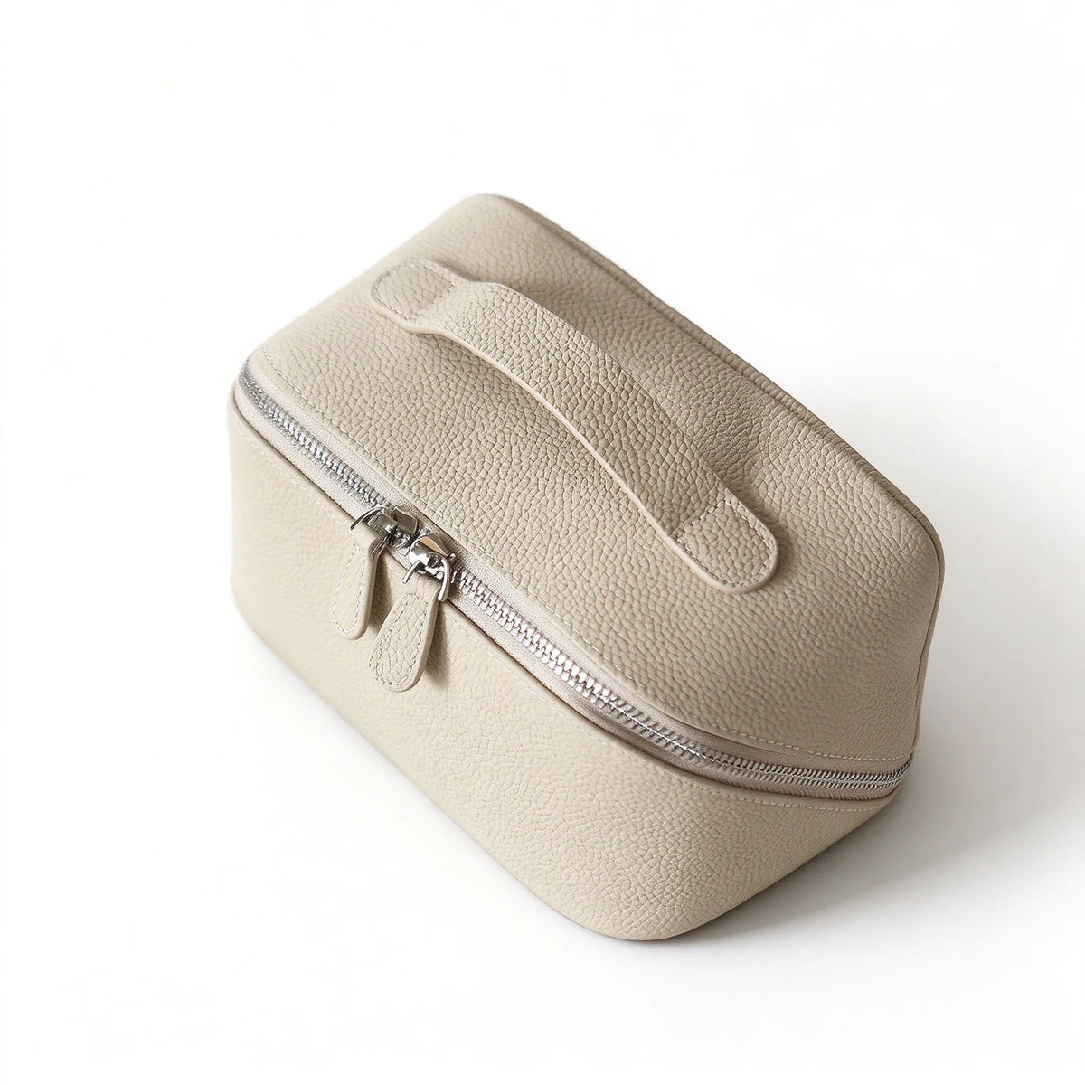 Top angled view of an off-white leather makeup bag showing the carry handle, pebbled texture and double zip pulls.
