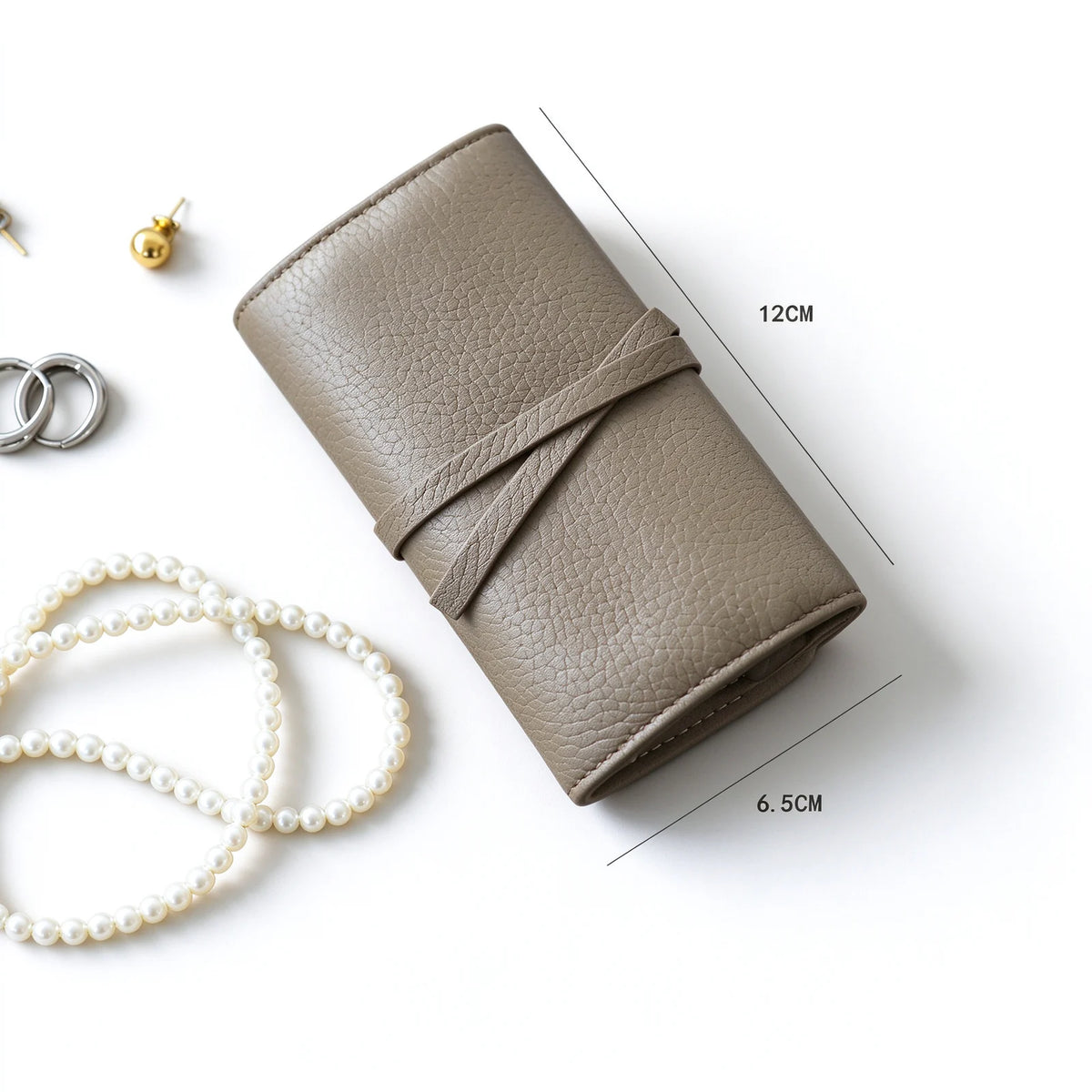 Taupe leather jewelry roll with a wraparound tie shown with dimension guide lines