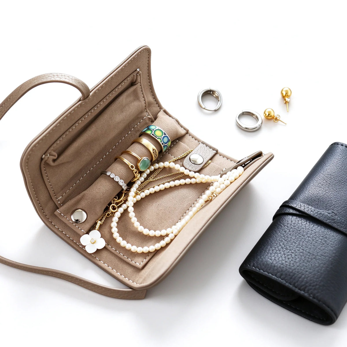 Open taupe leather jewelry roll showing the ring bar, retaining tabs and interior pocket