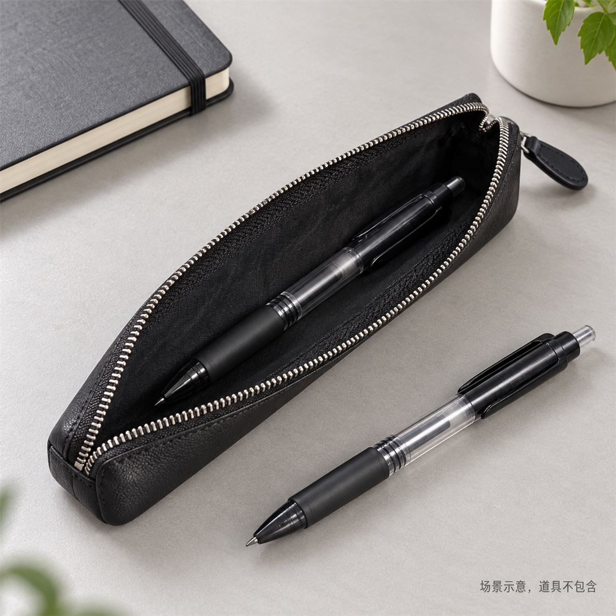 Illustrative office scene with an open SN005 black pencil case holding a pen beside a notebook.