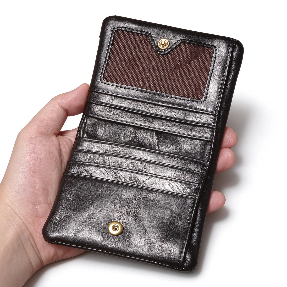 Black leather wallet opened vertically to show card slots, an identification window and gold-tone snap hardware.