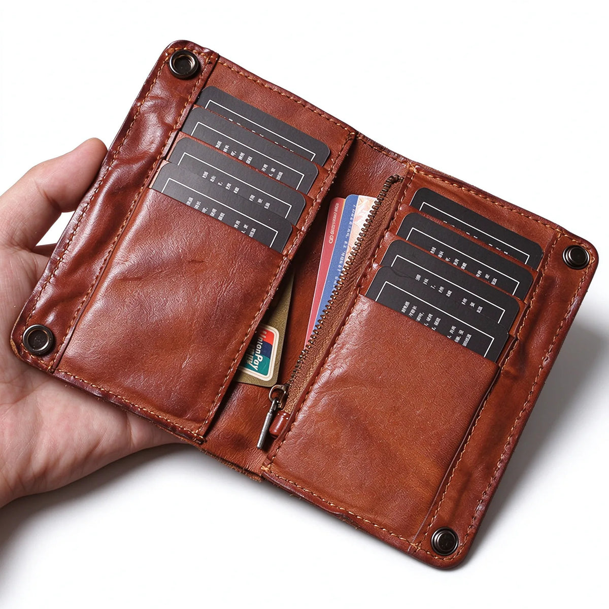 Open brown leather bifold wallet with card slots on both sides and a central zip pocket.