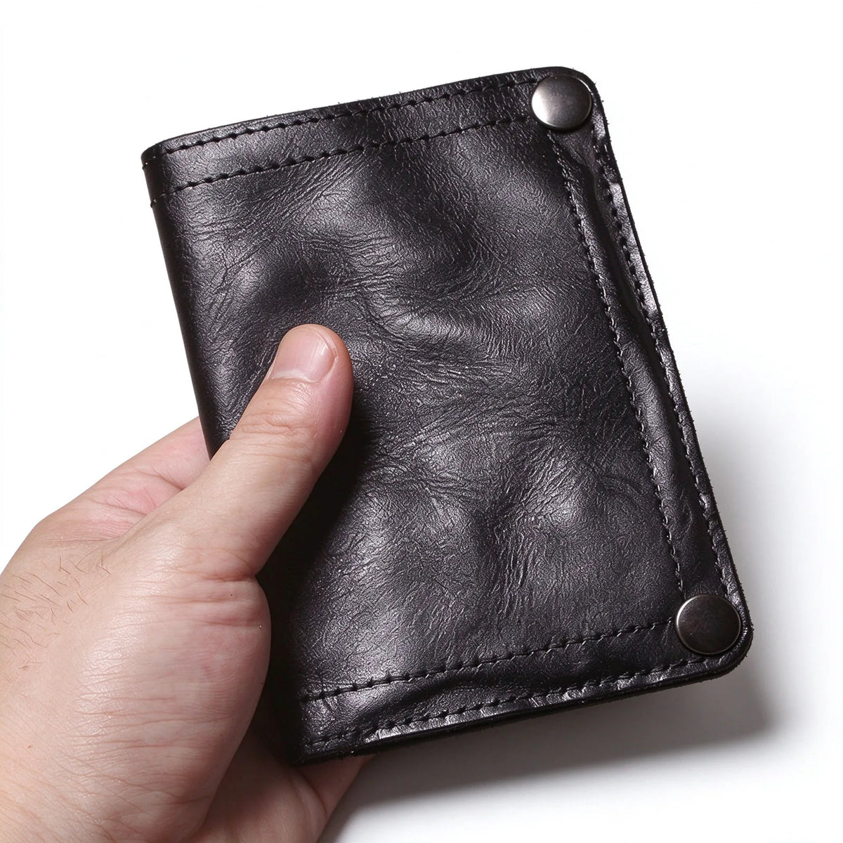 Front close-up of a black leather wallet with matching edge stitching and two dark snap fasteners.