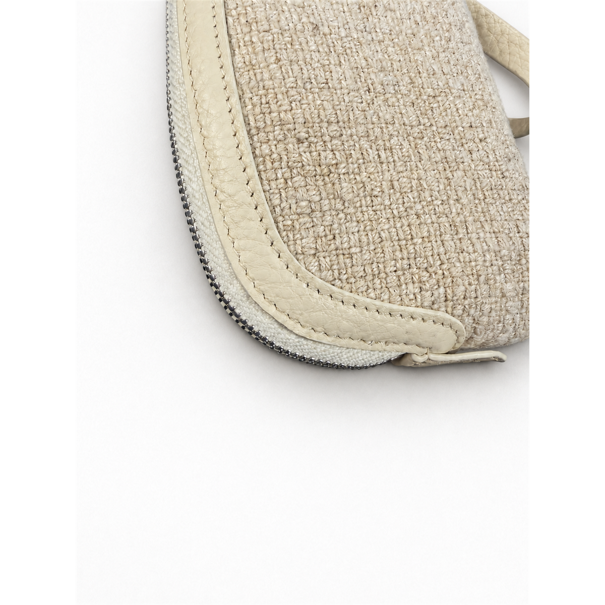 Close-up of the coin purse's cream woven texture, light trim and visible edge stitching.